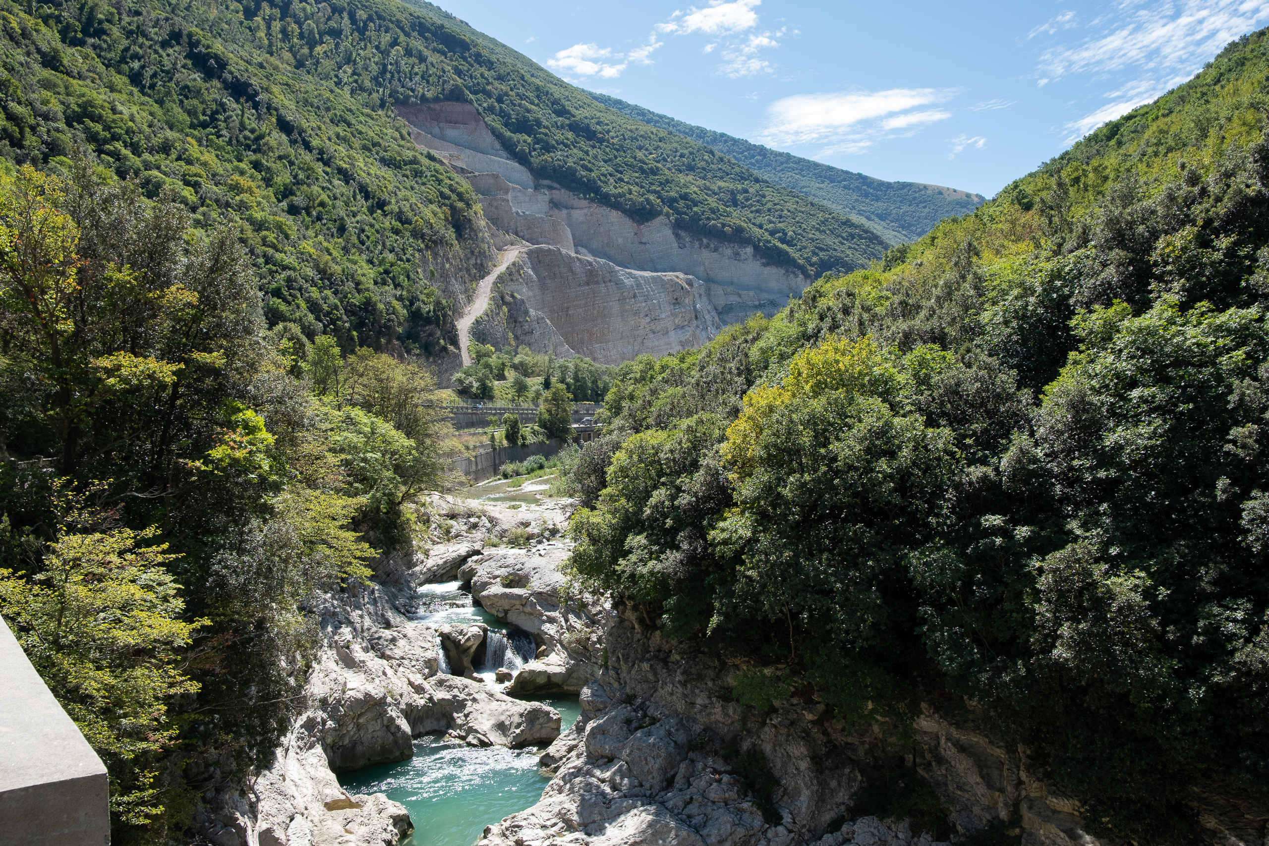 Türkise Gumpen in der Schlucht – darüber ein Steinbruch